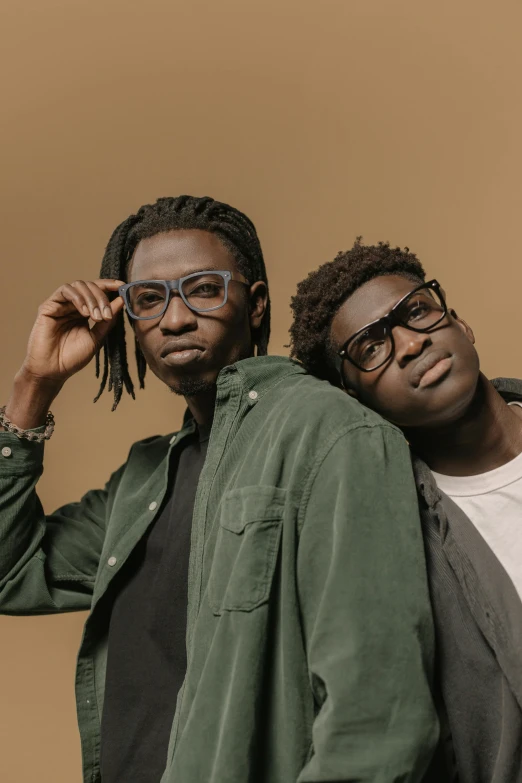 two men pose for a picture one wearing glasses