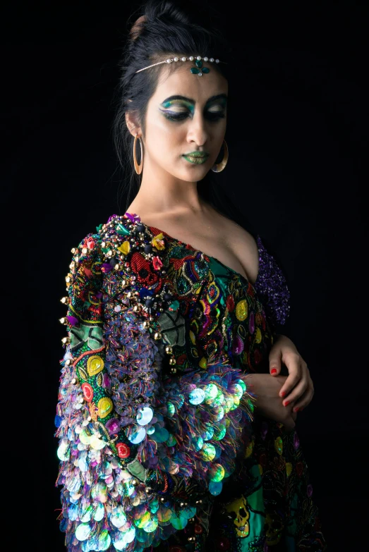 woman wearing green makeup while standing in a black background