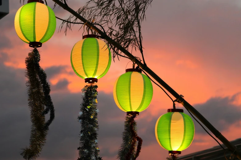 five yellow lanterns are hanging from a pole