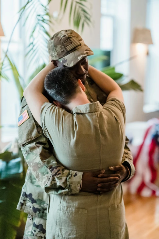 a man hugging his military companion in a house