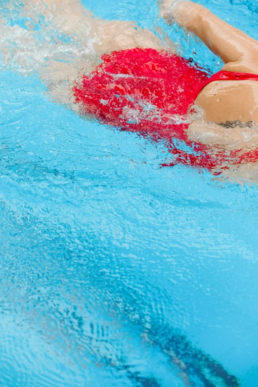 a woman in a red swimsuit swimming in the pool