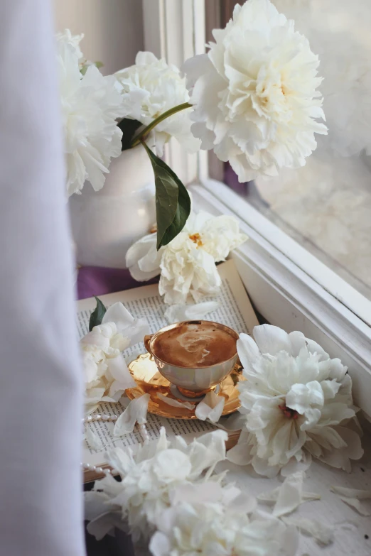 flowers, a vase with one flower, and a cup on a table