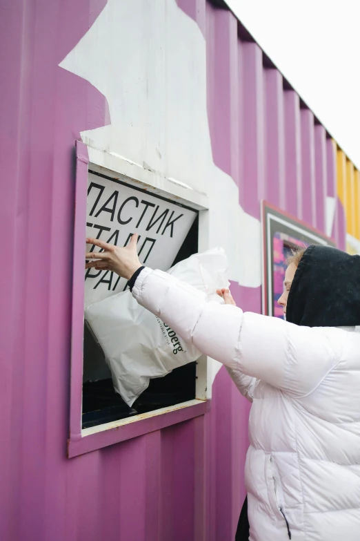 the woman is holding a sign in a purple building