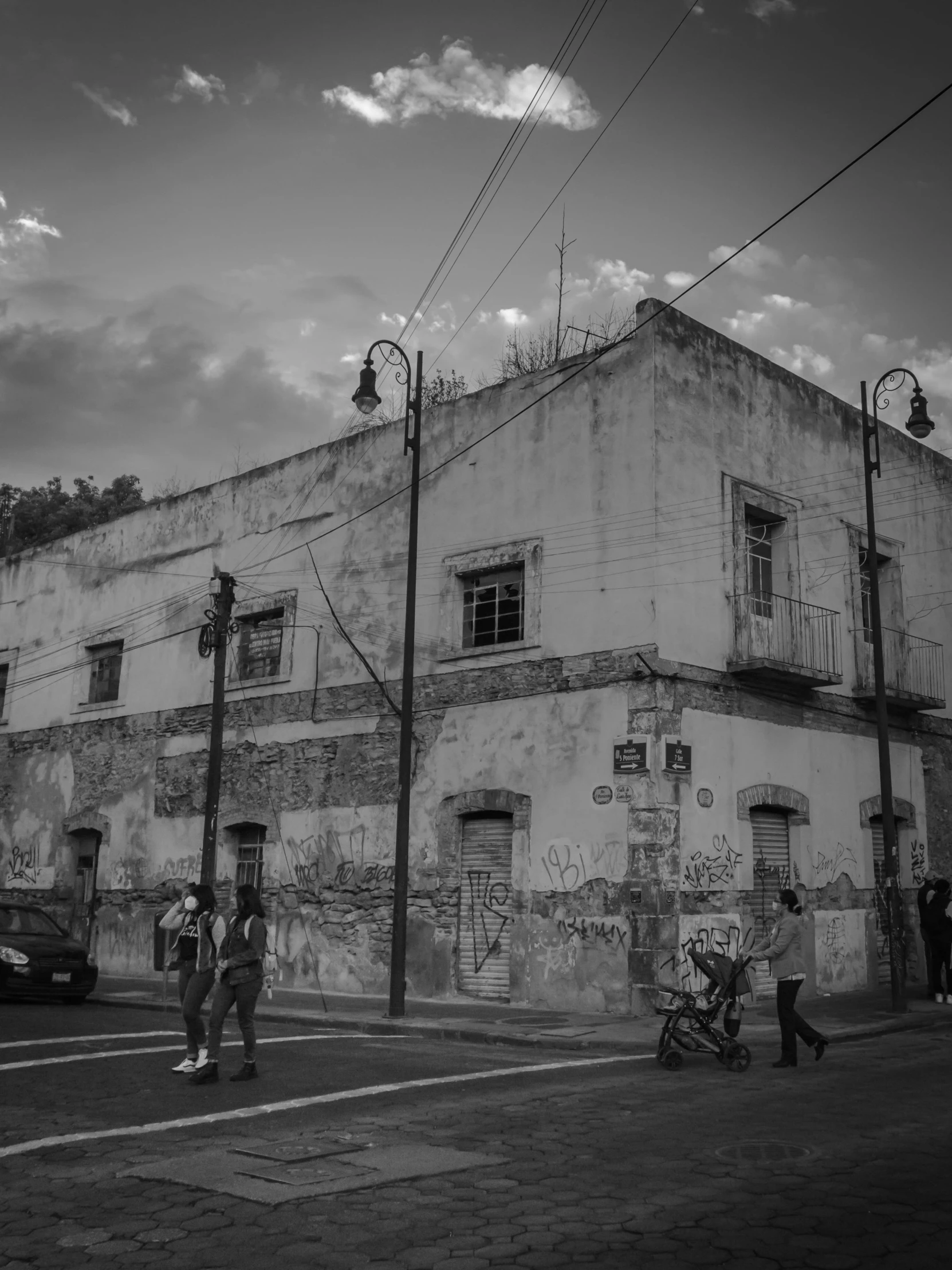 several people walking past an old brick building