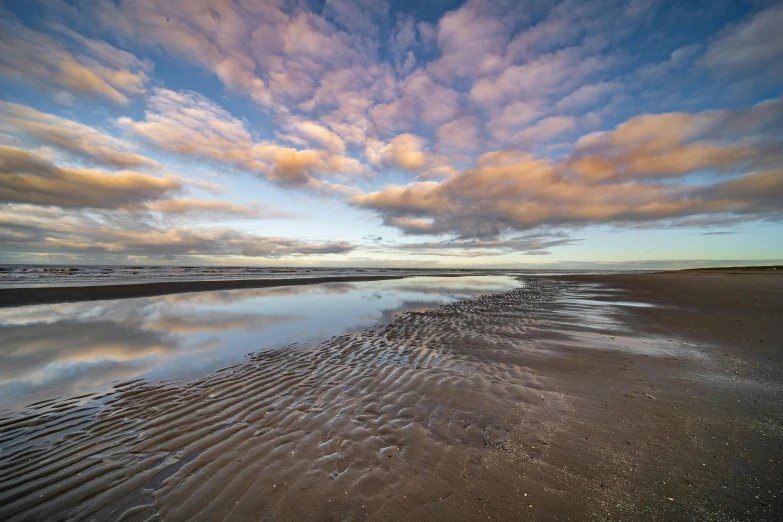 a beach with a very wide expanse of water on it