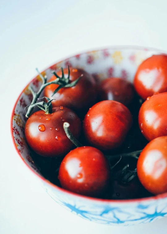 a blue and white bowl full of tomatoes