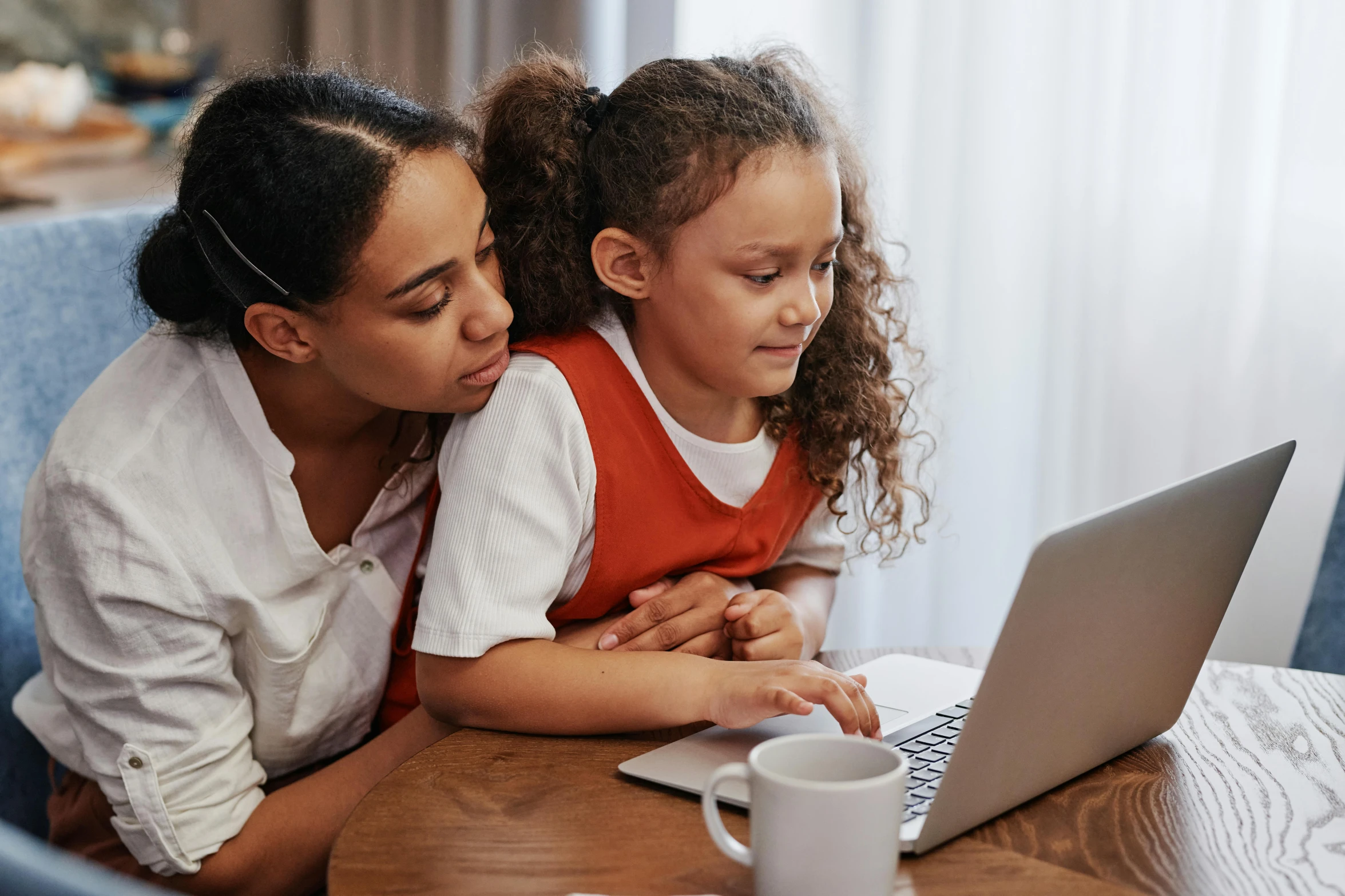 mother with her little daughter browsing on a laptop