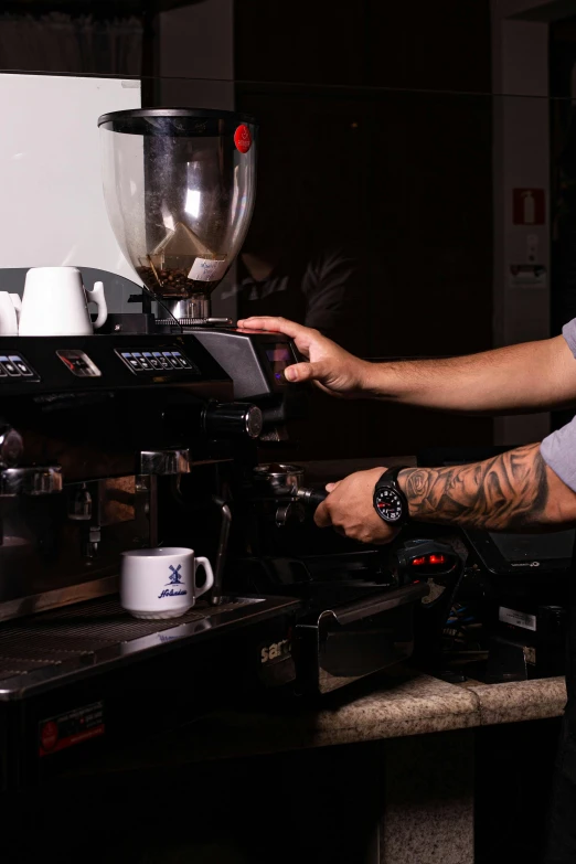 a person making a coffee while holding an object over his hand