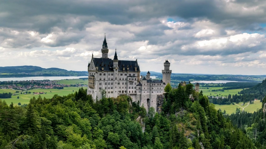 an elaborate castle on top of a hill in a countryside