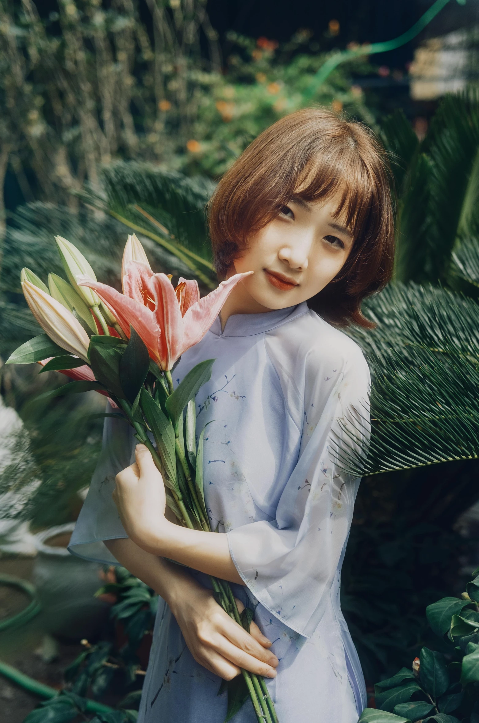 a woman in a blue dress holding pink flowers