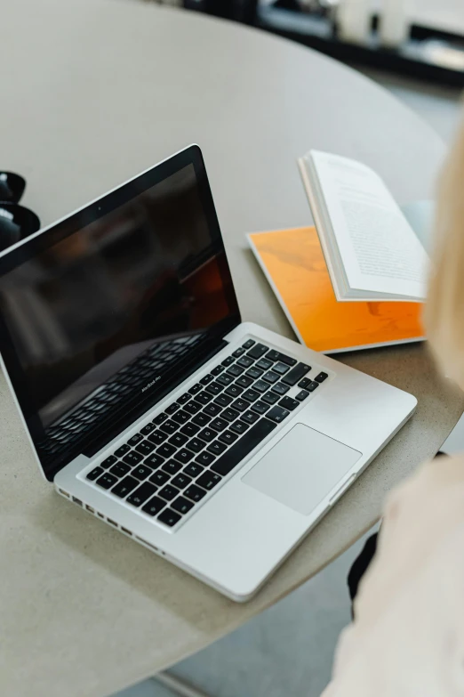 an open laptop sitting on a table with a notebook