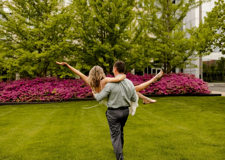 a man and woman in a field are holding each other