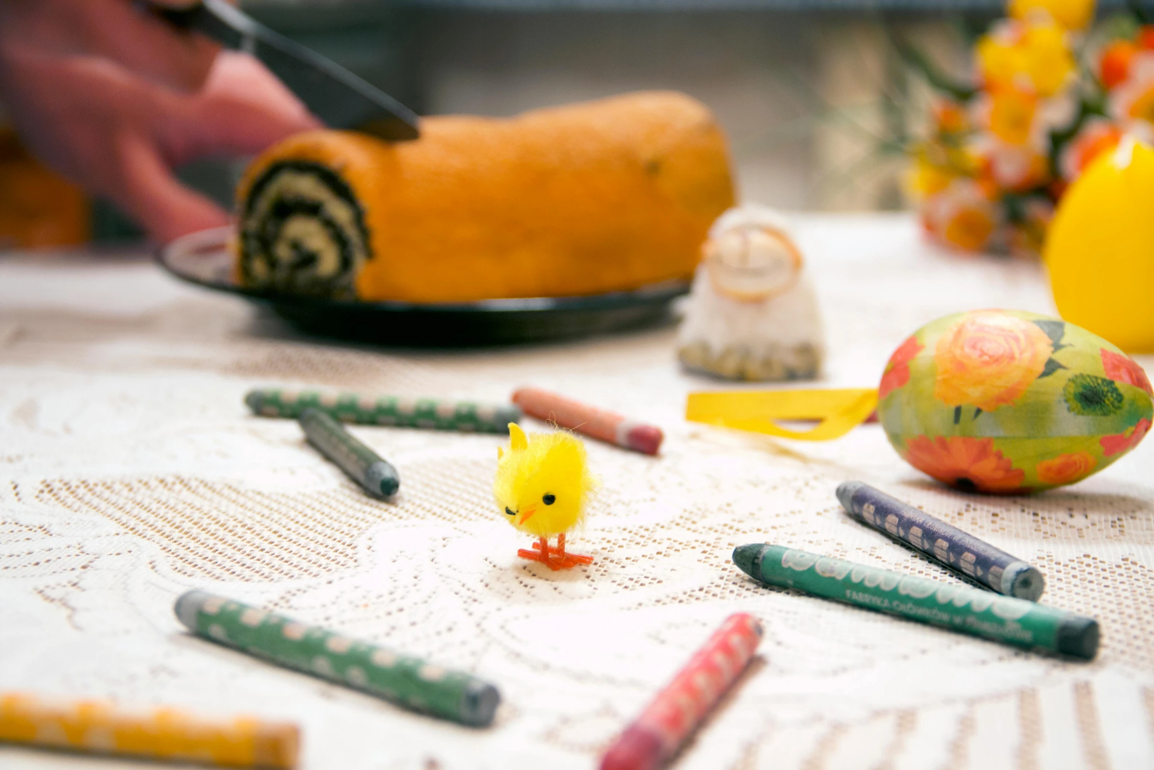 a small yellow duck sitting among some crayons