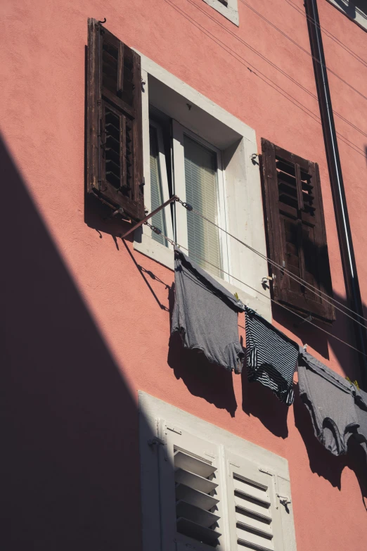 the outside of an old building with laundry hanging in front