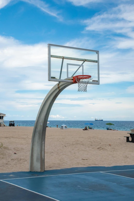 an empty basketball hoop at the beach with a basketball