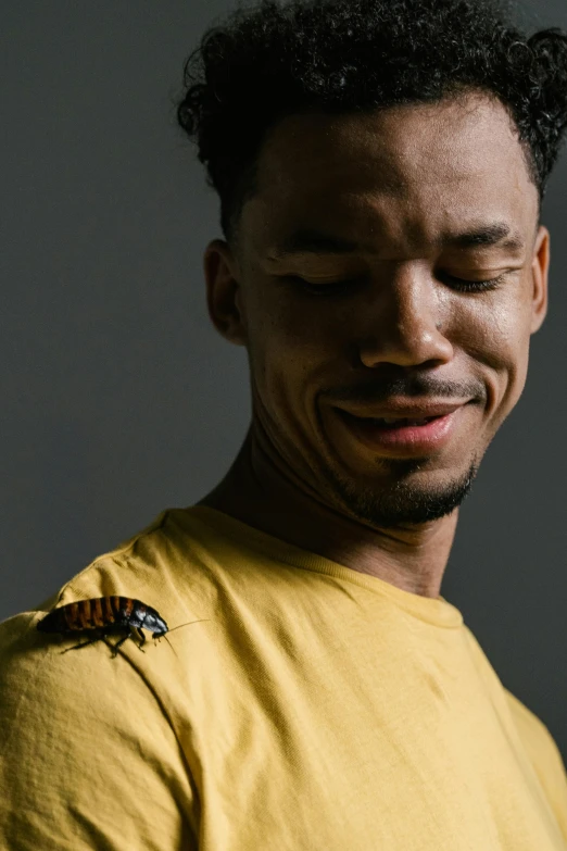 a smiling man with a bee on his left side