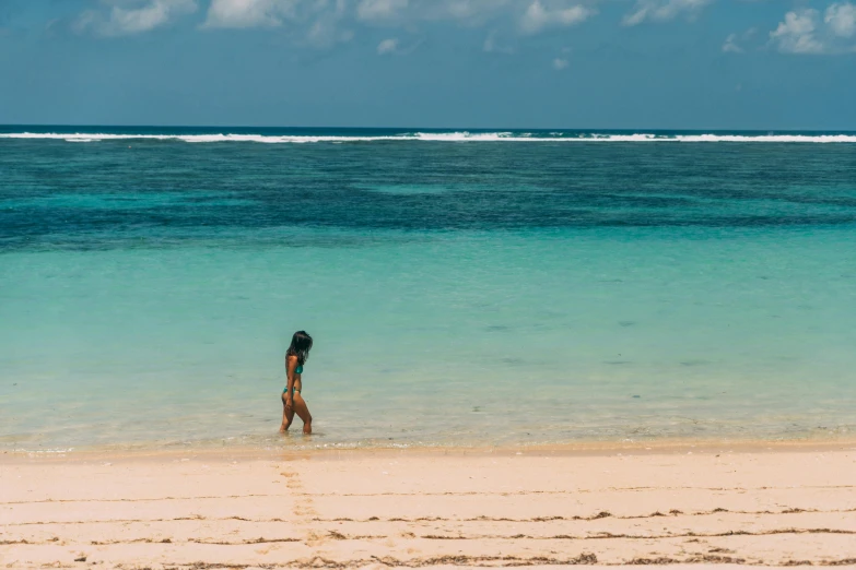 a person walking into the water at the beach