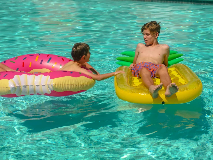 two boys playing in a swimming pool