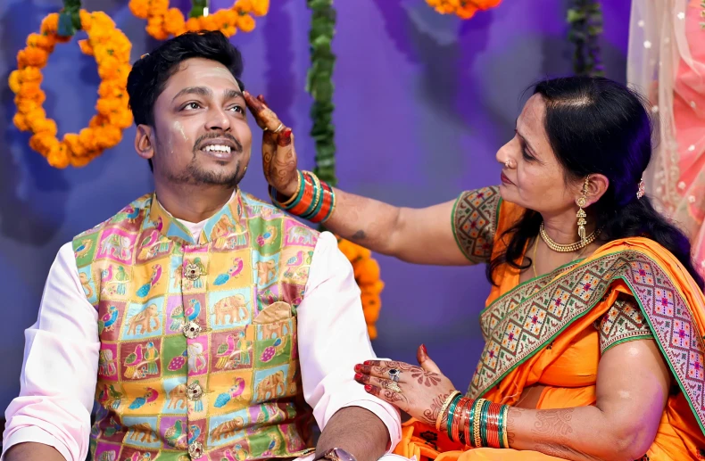 a woman puts a ring on a man's forehead