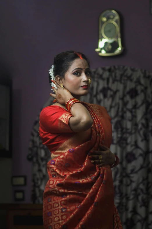 an attractive lady with red sari posing for a picture