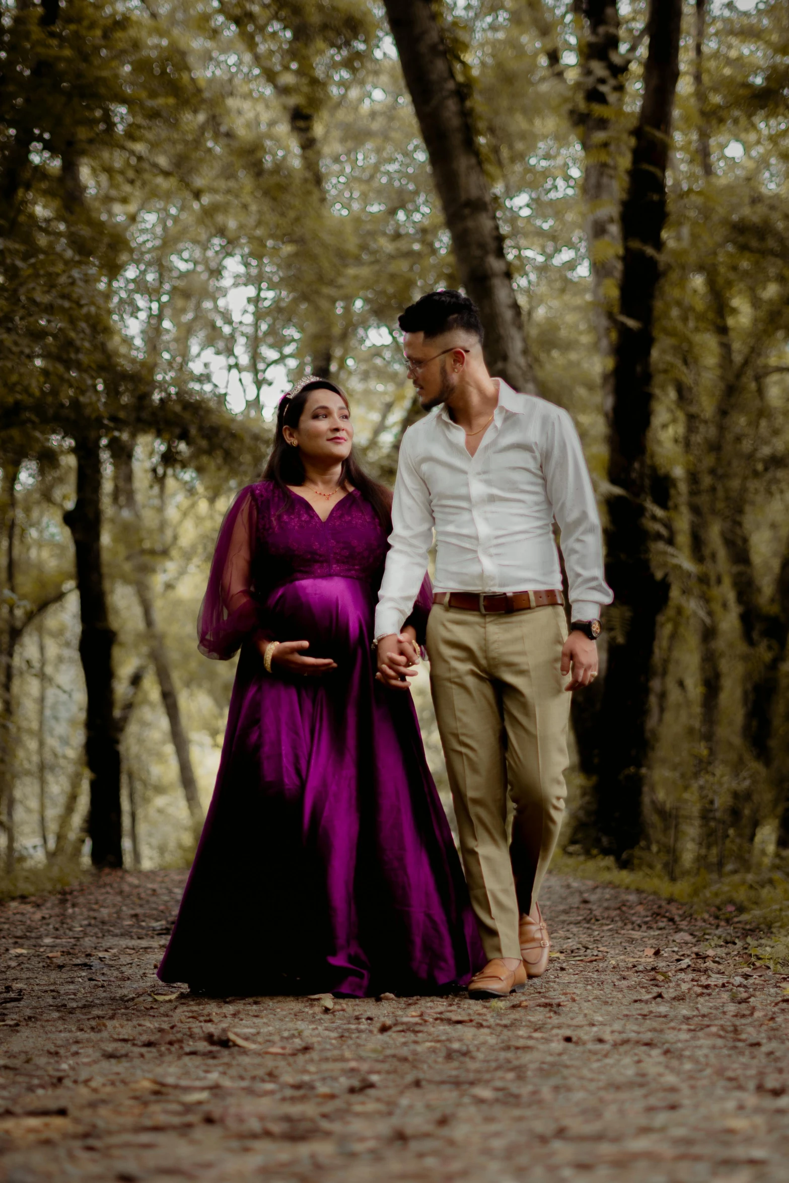 the couple are walking in the forest with each other