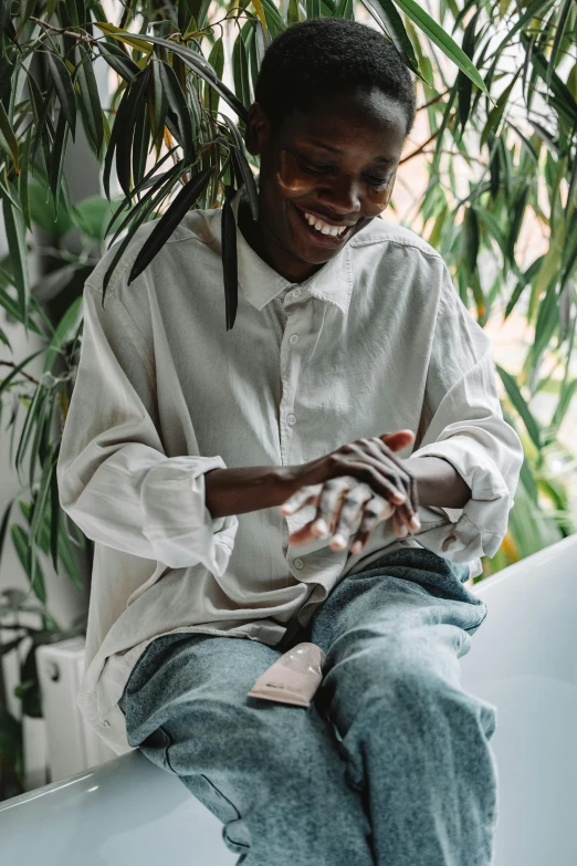 woman sitting down on a car, smiling and touching her hands