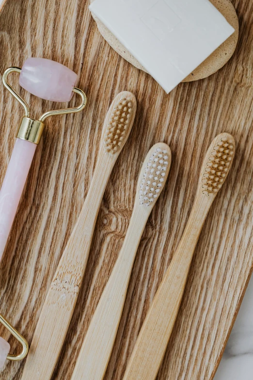 various types of decorative toothbrushes laying on a wooden tray