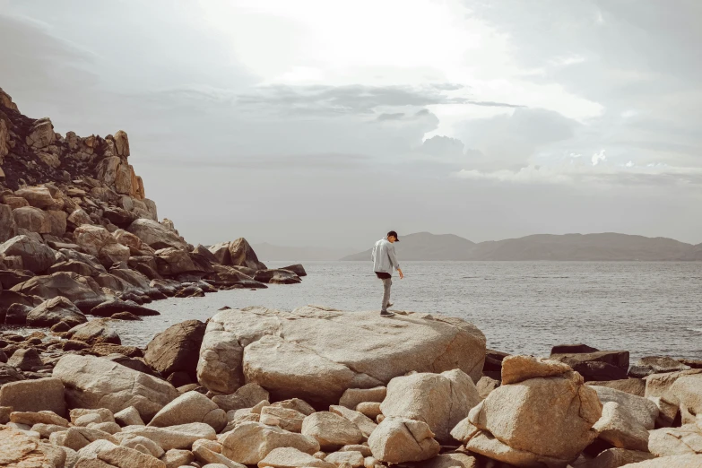 a person standing on rocks in front of water