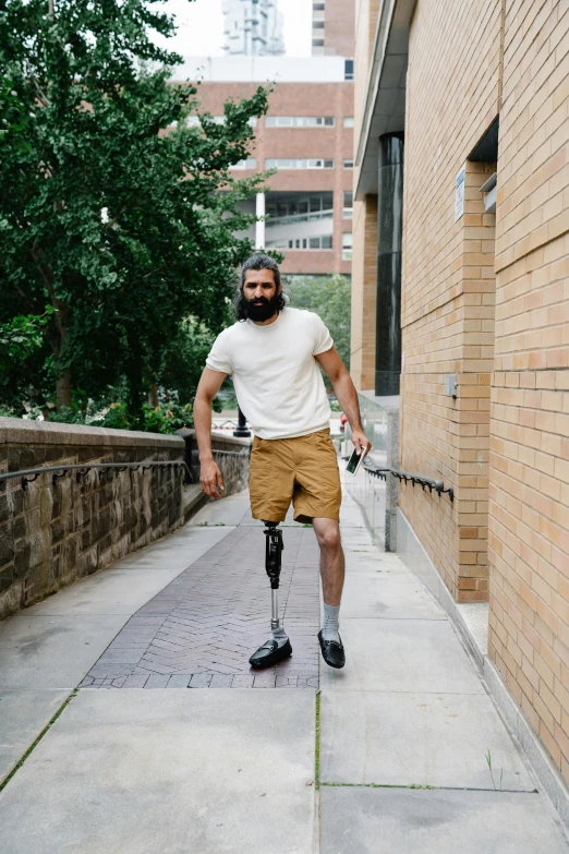 a man standing on the sidewalk wearing a crutch