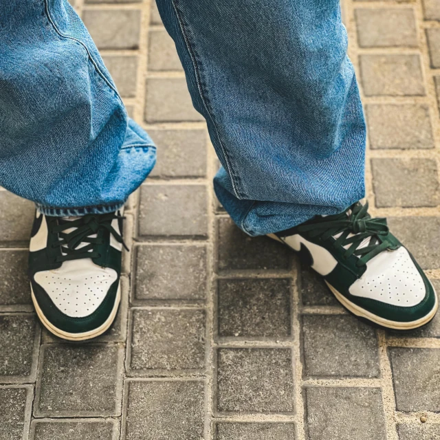 there is a man's feet standing with sneakers on