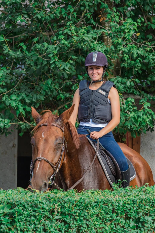 a woman rides on the back of a brown horse