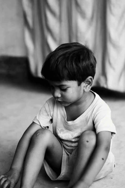 a black and white pograph of a toddler on the floor