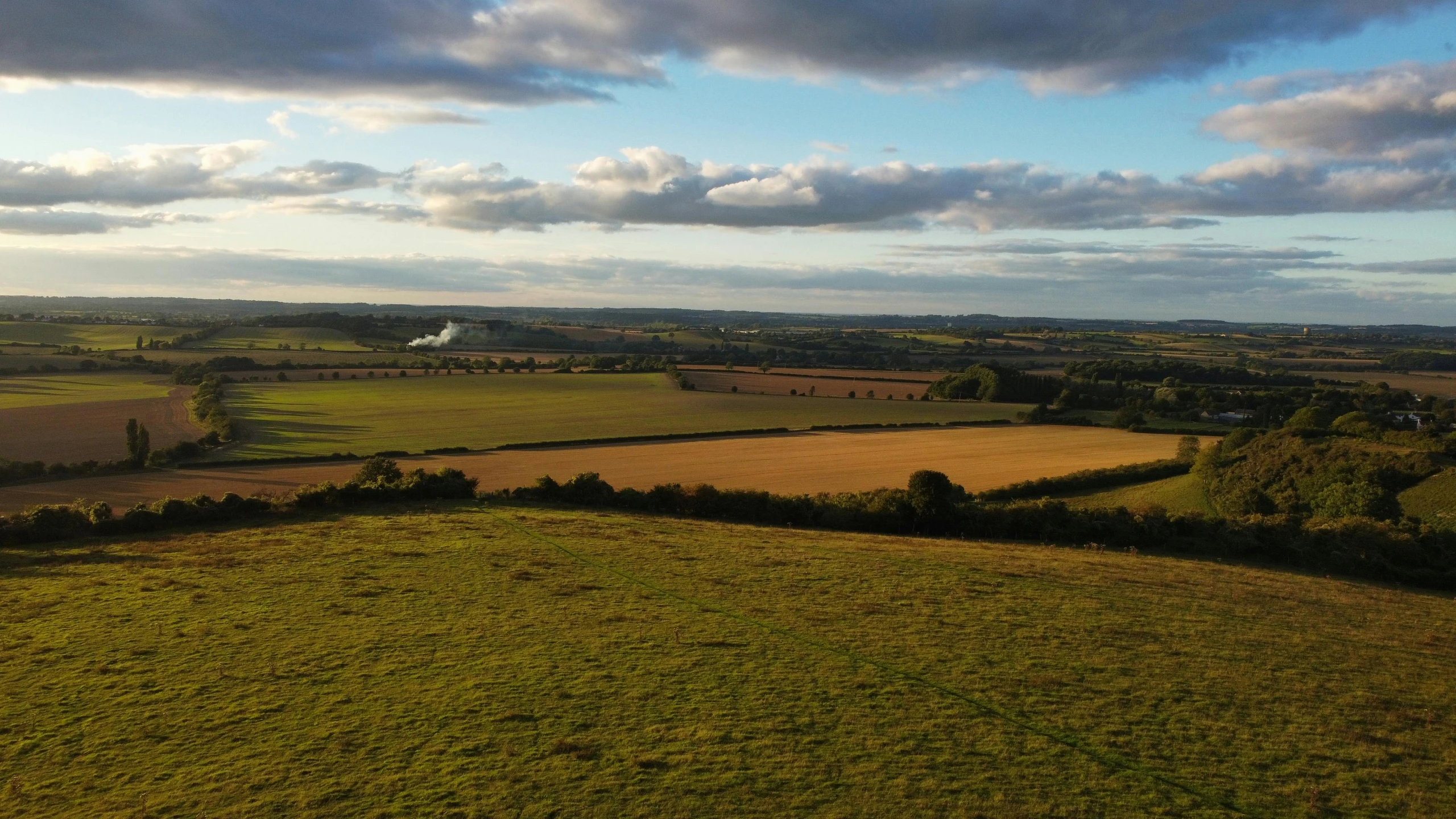 an aerial po shows grassy terrain with blue sky in background