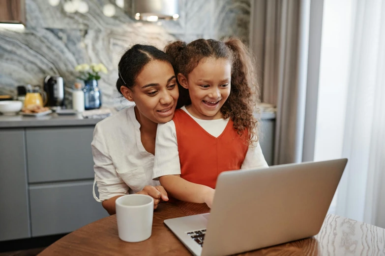 a mother and daughter on a laptop computer