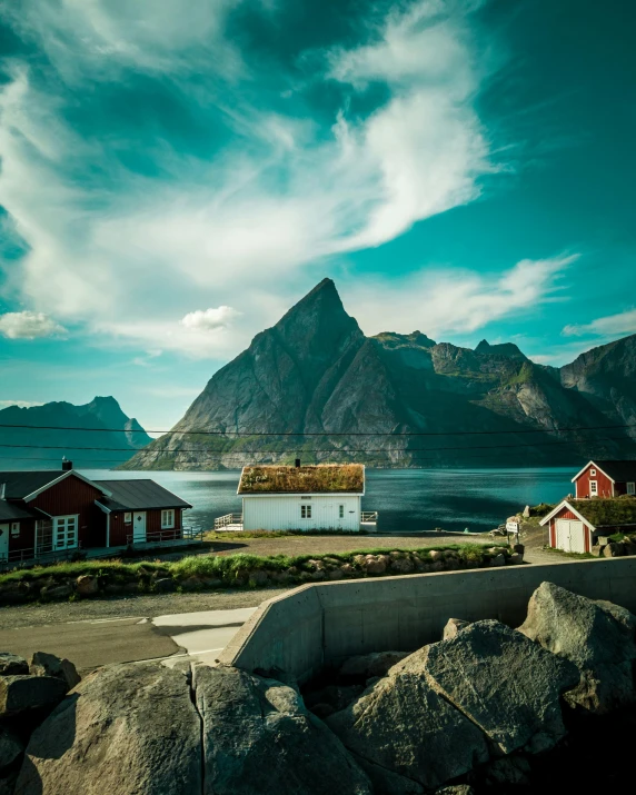 a small red house by the sea with a mountain in the background