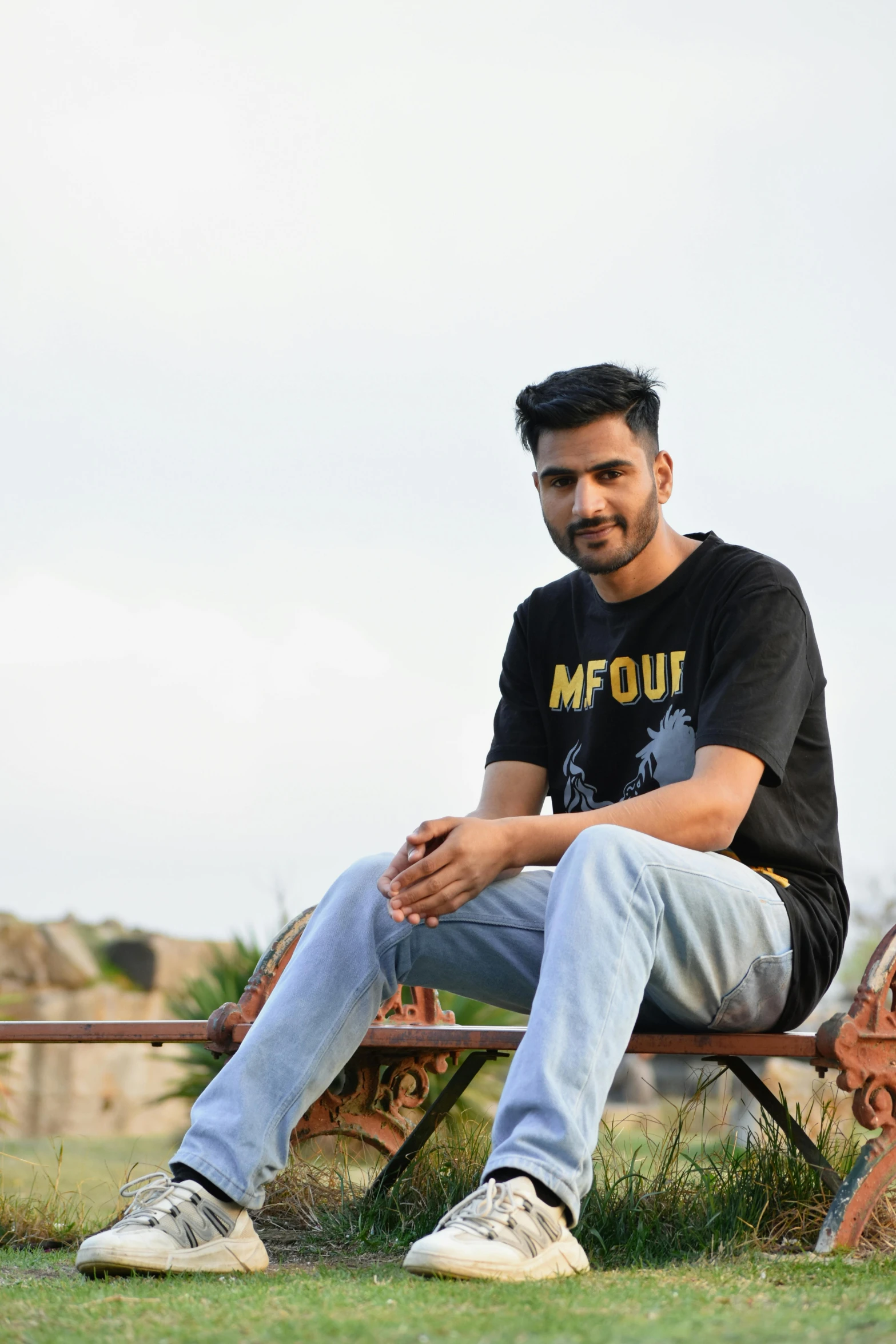 a young man sitting on top of a bench