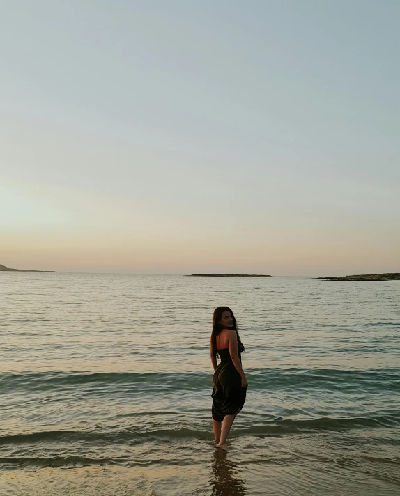 a woman in swim trunks walking across a beach