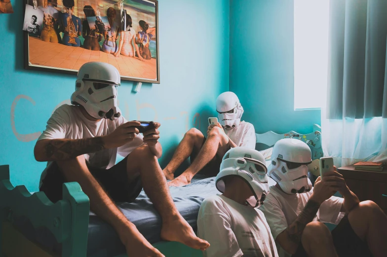 a man is sitting in his bedroom with several people