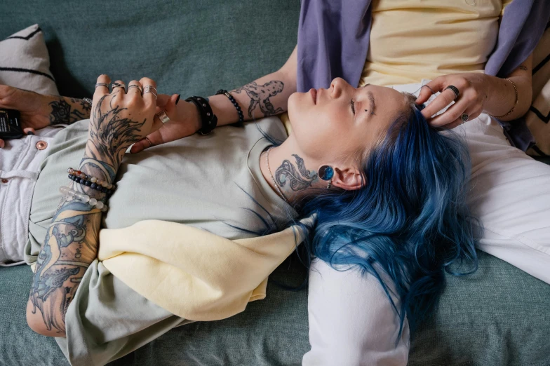 a person laying on a couch with a blue wig