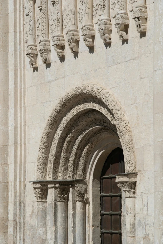 a stone arch with a gate and some windows