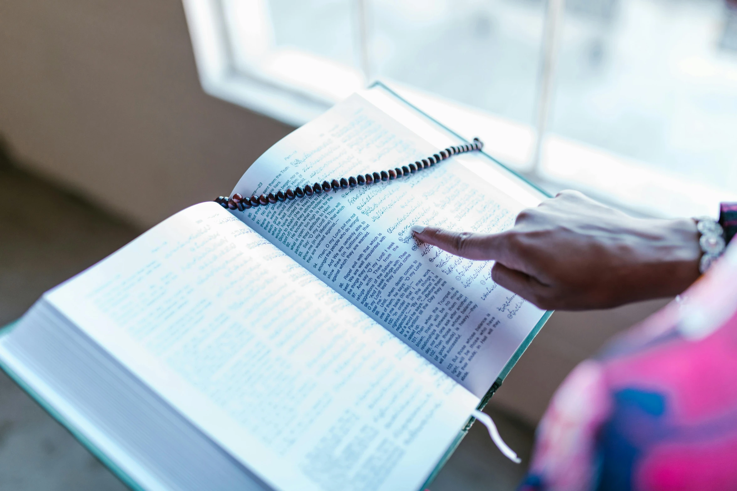 a person holding a book with some beads