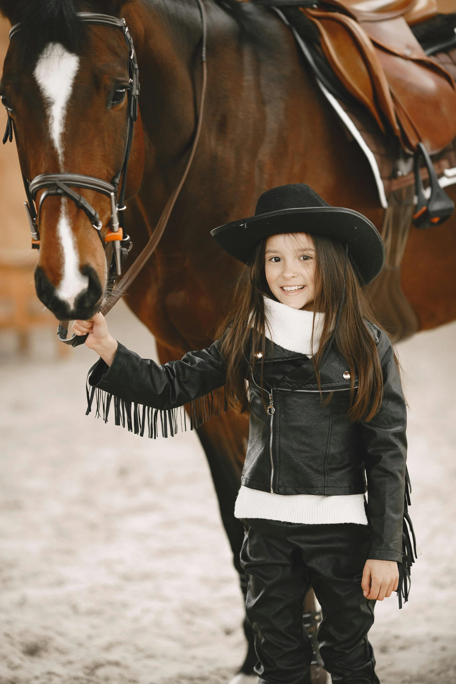 a  poses next to a horse in a stable