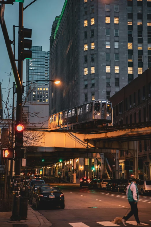 people crossing the street in front of some tall buildings