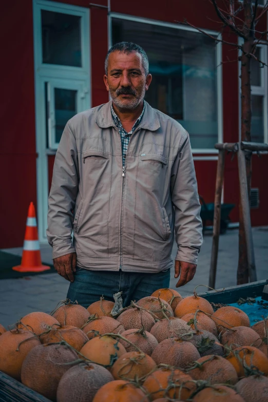 a man is standing next to the fruit stand