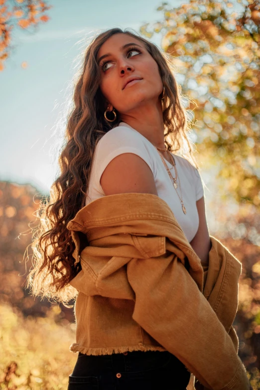 young beautiful woman wearing clothes poses outside on the grass