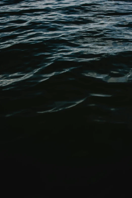 some dark colored water with a surfer