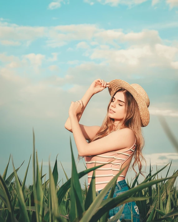 young woman standing in tall grass and blue sky