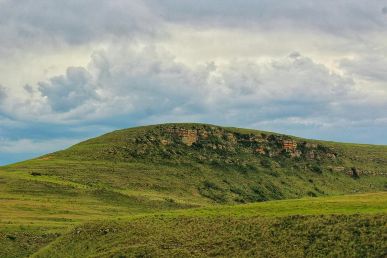 a very large mountain with trees on top