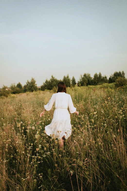 a woman is running through the tall grass