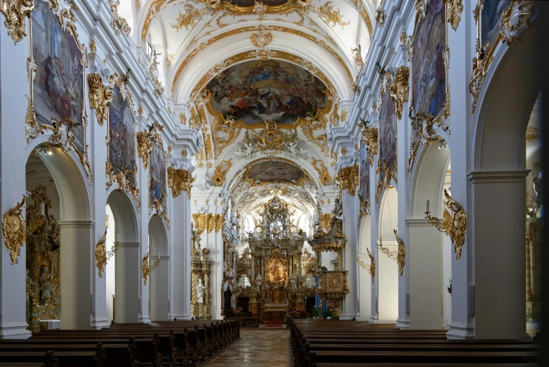 a church with several pews and gold decorations on them